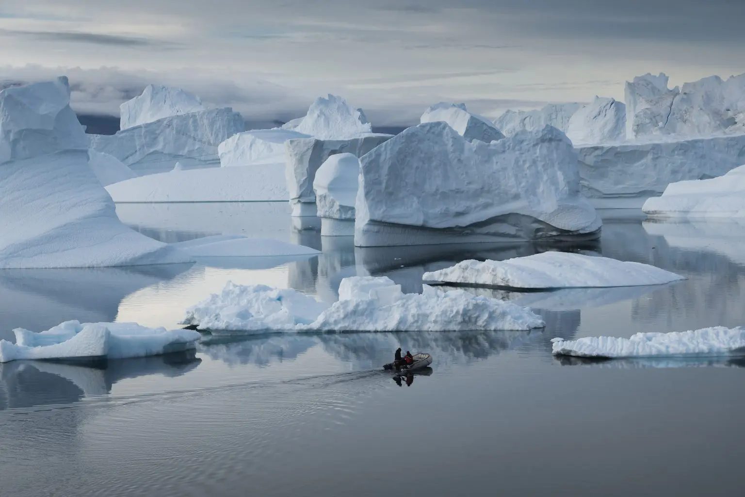 a small boat and icebergs in Greenland